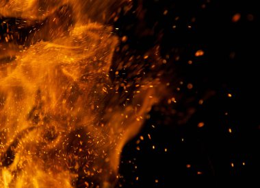 Siyah arkaplanda kıvılcımlar saçan ateş alevleri