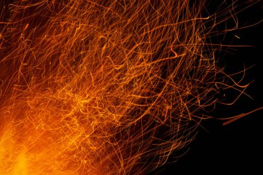 Siyah arkaplanda kıvılcımlar saçan ateş alevleri