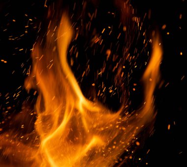 Siyah arkaplanda kıvılcımlar saçan ateş alevleri