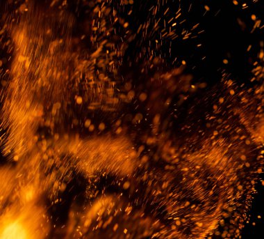 Siyah arkaplanda kıvılcımlar saçan bir ateş alevi