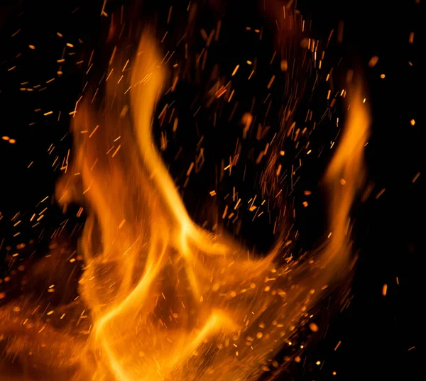Siyah arkaplanda kıvılcımlar saçan ateş alevleri