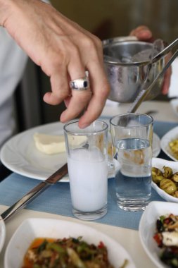Özel Alkollü İçkili Rakılı Türk ve Yunan Geleneksel Yemek Masası. Uzo ve Türk Rakısı, Türkiye, Yunanistan, Kıbrıs ve Lübnan'da yaygın olarak tüketilen kuru anason aromalı bir aperatiftir.