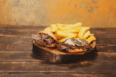 Doner kebabı kesme tahtasının üzerinde duruyor. Et, soğan ve salata ile Shawarma eski ve karanlık bir tahta masada yatıyor.