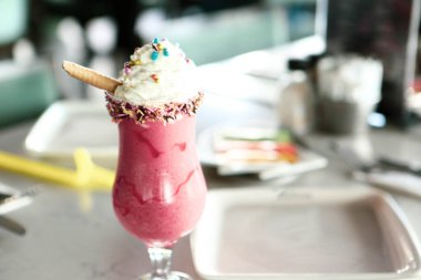 Bir bardak ahududu milkshake, krem şanti ve taze ahududu.