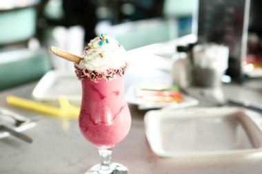 Bir bardak ahududu milkshake, krem şanti ve taze ahududu.