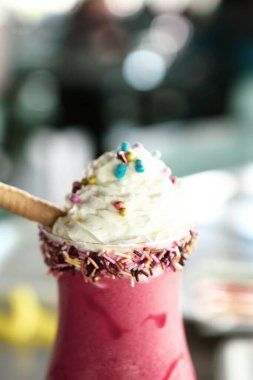 Bir bardak ahududu milkshake, krem şanti ve taze ahududu.