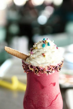 Bir bardak ahududu milkshake, krem şanti ve taze ahududu.