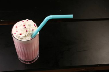 Bir bardak ahududu milkshake, krem şanti ve taze ahududu.