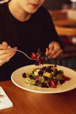 çekici beyaz salata, odak üstünde el yemek kadın ve çatal gülümseyen portresi.