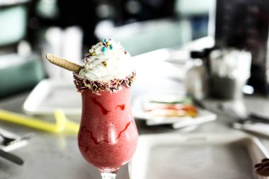 Bir bardak ahududu milkshake, krem şanti ve taze ahududu.