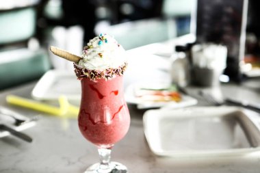 Bir bardak ahududu milkshake, krem şanti ve taze ahududu.