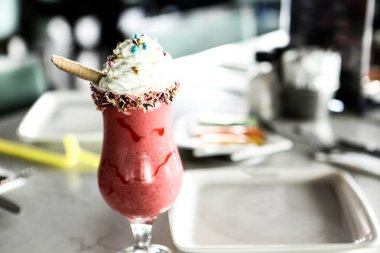 Bir bardak ahududu milkshake, krem şanti ve taze ahududu.