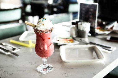 Bir bardak ahududu milkshake, krem şanti ve taze ahududu.