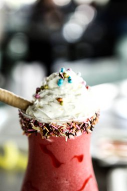 Bir bardak ahududu milkshake, krem şanti ve taze ahududu.