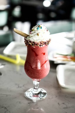 Bir bardak ahududu milkshake, krem şanti ve taze ahududu.