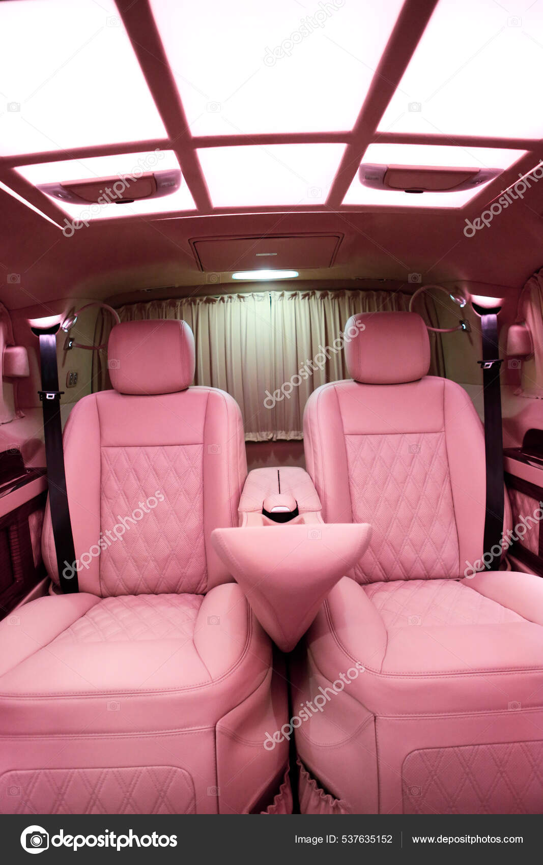 This luxury modern pink car interior is sleek and stylish, featuring soft pink leather seats and a futuristic dashboard with high-tech features. The combination of the pink color scheme and the cutting-edge design elements create a unique and glamorous driving experience.