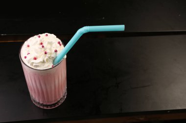 Bir bardak ahududu milkshake, krem şanti ve taze ahududu.