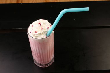 Bir bardak ahududu milkshake, krem şanti ve taze ahududu.
