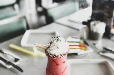 Bir bardak ahududu milkshake, krem şanti ve taze ahududu.