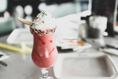 Bir bardak ahududu milkshake, krem şanti ve taze ahududu.