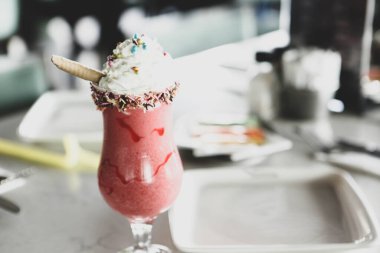 Bir bardak ahududu milkshake, krem şanti ve taze ahududu.