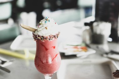 Bir bardak ahududu milkshake, krem şanti ve taze ahududu.