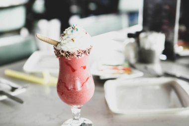 Bir bardak ahududu milkshake, krem şanti ve taze ahududu.