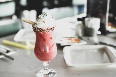 Bir bardak ahududu milkshake, krem şanti ve taze ahududu.