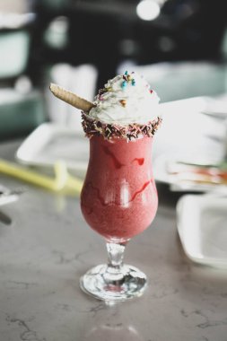 Bir bardak ahududu milkshake, krem şanti ve taze ahududu.