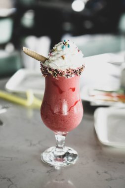 Bir bardak ahududu milkshake, krem şanti ve taze ahududu.