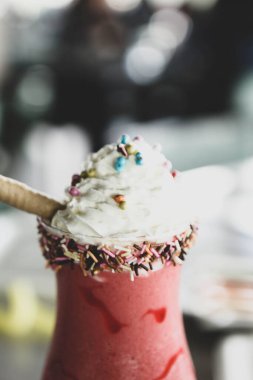 Bir bardak ahududu milkshake, krem şanti ve taze ahududu.