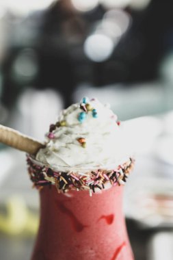 Bir bardak ahududu milkshake, krem şanti ve taze ahududu.