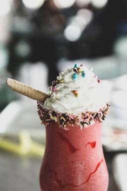 Bir bardak ahududu milkshake, krem şanti ve taze ahududu.