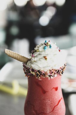 Bir bardak ahududu milkshake, krem şanti ve taze ahududu.