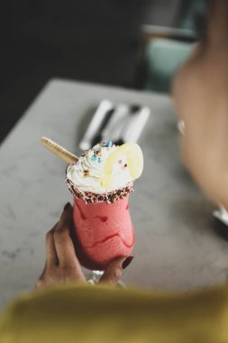 Bir bardak ahududu milkshake, krem şanti ve taze ahududu.