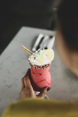 Bir bardak ahududu milkshake, krem şanti ve taze ahududu.