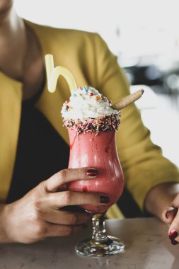 Bir bardak ahududu milkshake, krem şanti ve taze ahududu.