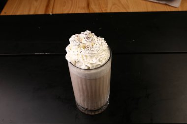 Sütlü buzlu kahve. Buzlu kahve. Elinde bir bardak buzlu kahve tutan kadın..