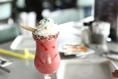 Bir bardak ahududu milkshake, krem şanti ve taze ahududu.