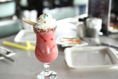 Bir bardak ahududu milkshake, krem şanti ve taze ahududu.