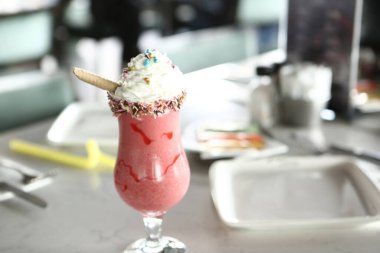 Bir bardak ahududu milkshake, krem şanti ve taze ahududu.