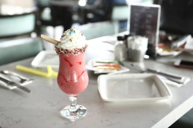 Bir bardak ahududu milkshake, krem şanti ve taze ahududu.