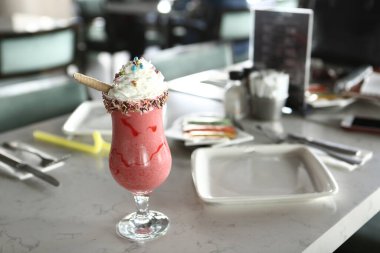 Bir bardak ahududu milkshake, krem şanti ve taze ahududu.