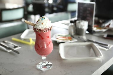 Bir bardak ahududu milkshake, krem şanti ve taze ahududu.