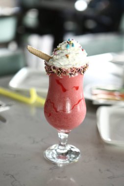 Bir bardak ahududu milkshake, krem şanti ve taze ahududu.