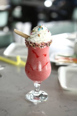 Bir bardak ahududu milkshake, krem şanti ve taze ahududu.