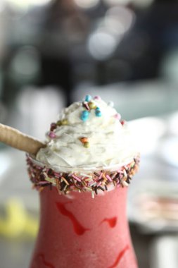 Bir bardak ahududu milkshake, krem şanti ve taze ahududu.