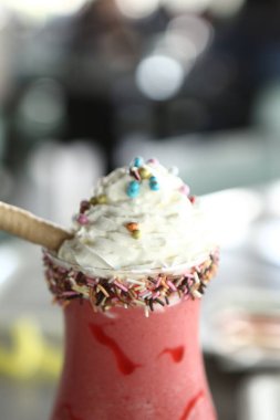 Bir bardak ahududu milkshake, krem şanti ve taze ahududu.