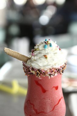 Bir bardak ahududu milkshake, krem şanti ve taze ahududu.