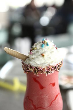 Bir bardak ahududu milkshake, krem şanti ve taze ahududu.